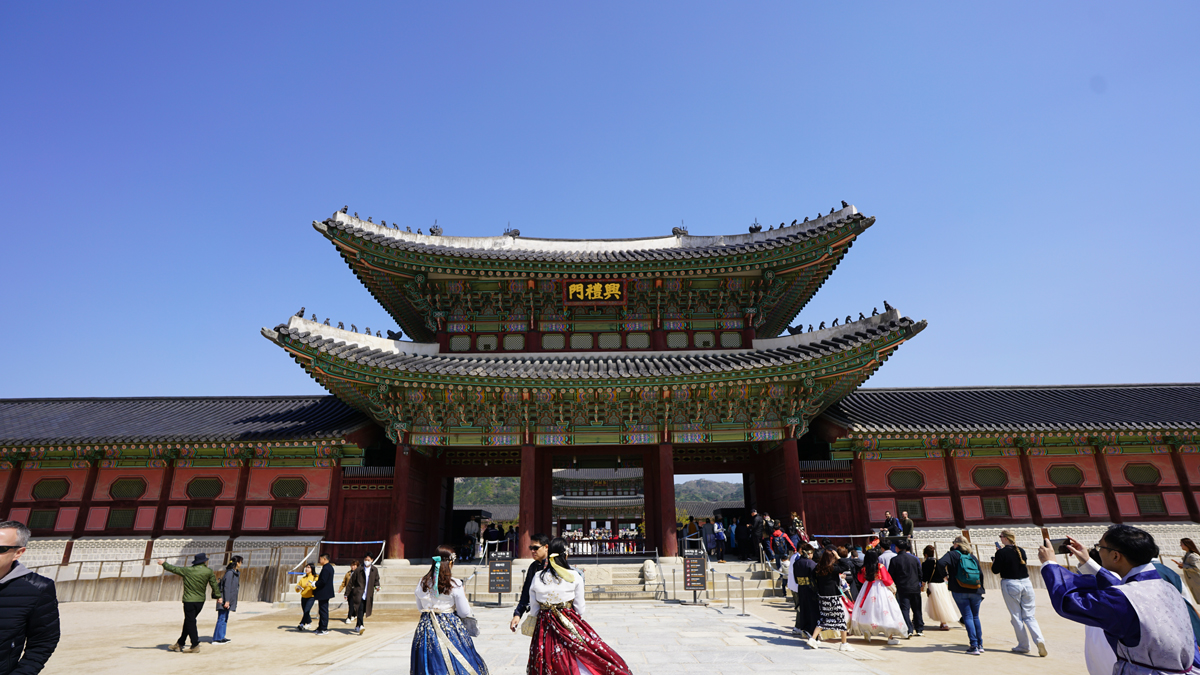Gyeongbokgung palace with many wearing traditional hanbok.